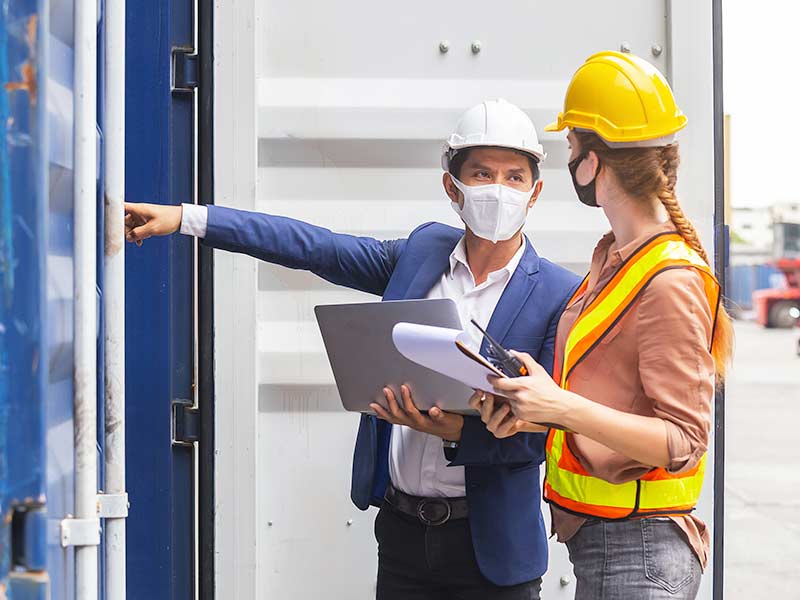 Two people in hard hats inspect a facility