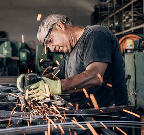 A man works on machine and sparks fly